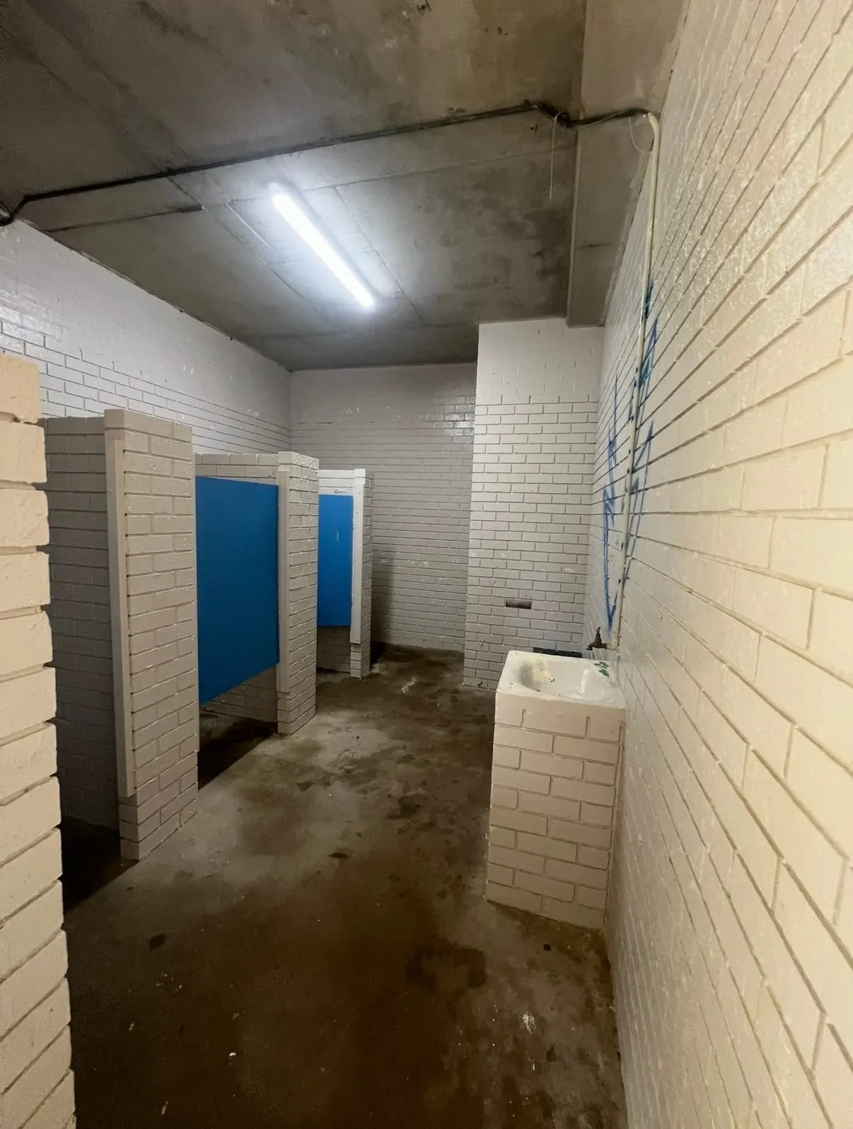 Nambucca Heads Main Beach amenities before refurbishment, with worn brickwork and stained floor