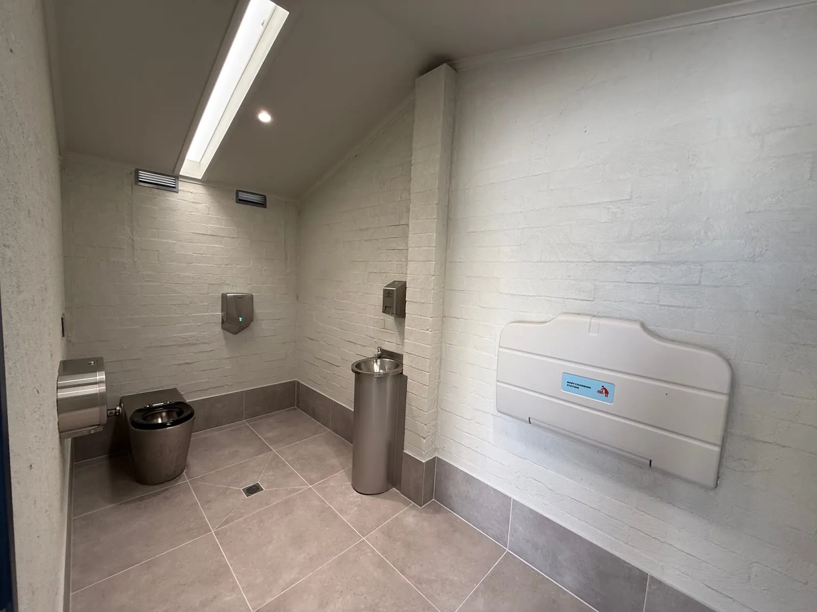 Interior of the rebuilt River Street amenities with skylight, baby change table and tiled floor