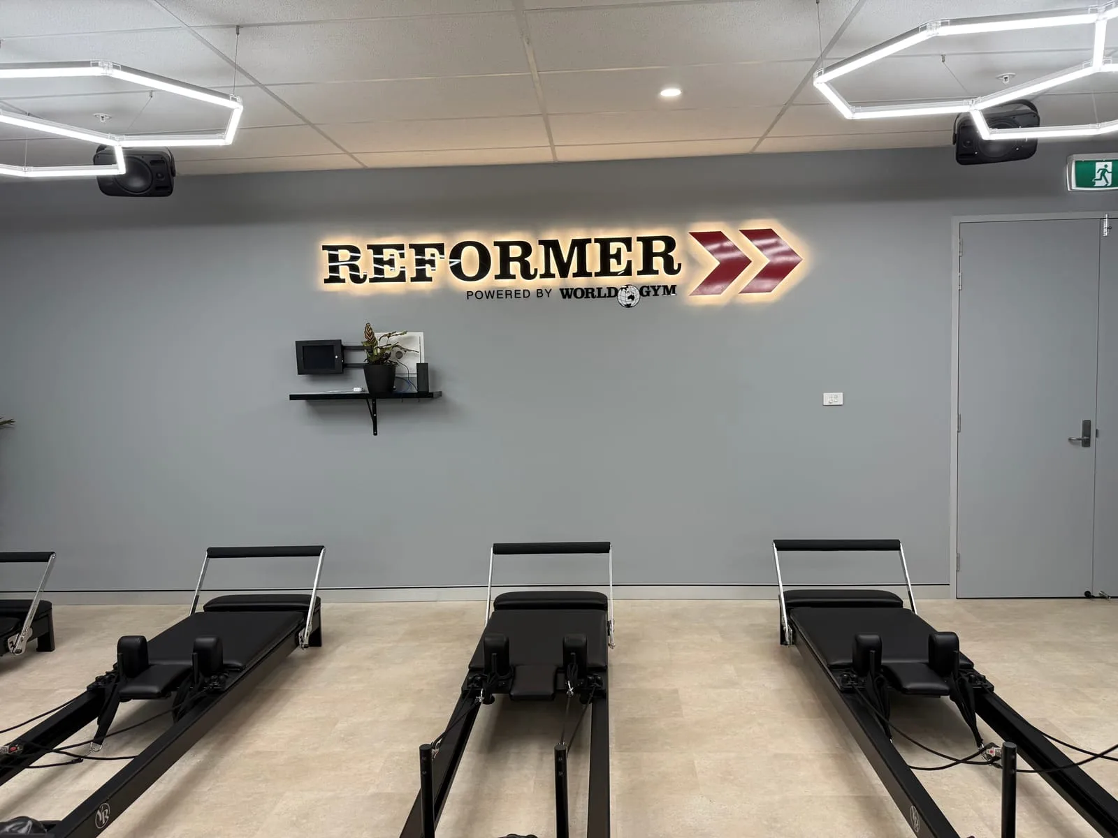 Reformer signage wall and feature lighting in the World Gym Coffs Harbour studio