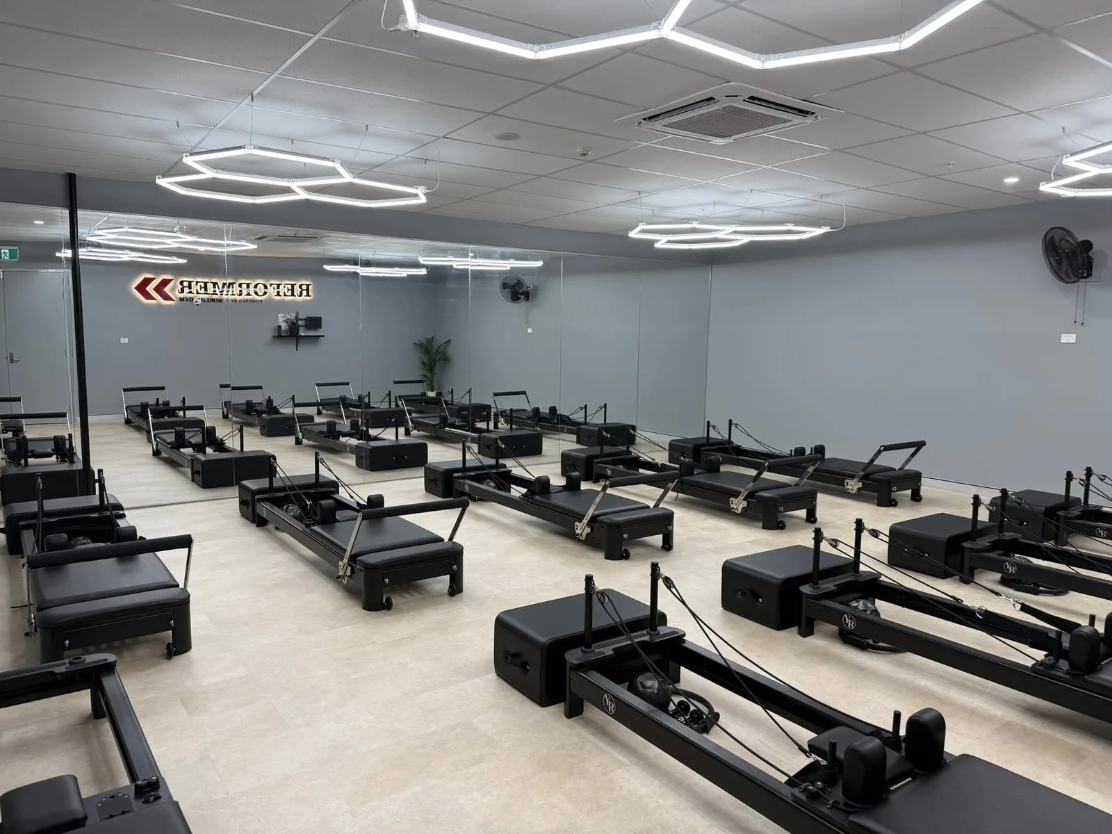 Wide view of the World Gym Coffs Harbour reformer studio with rows of reformer beds