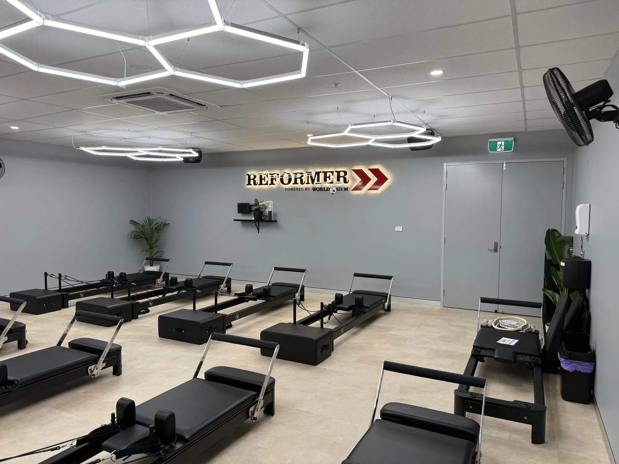 Completed reformer pilates studio at World Gym Coffs Harbour under hexagon feature lighting